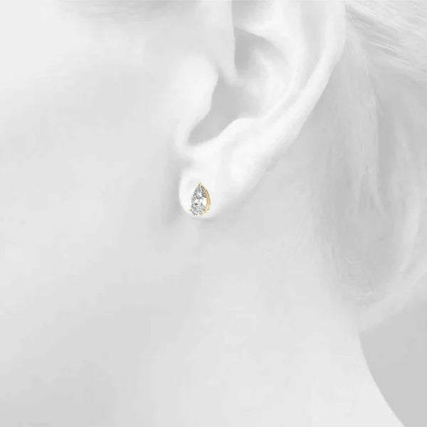 Yellow gold earring on a girl's ear in a background