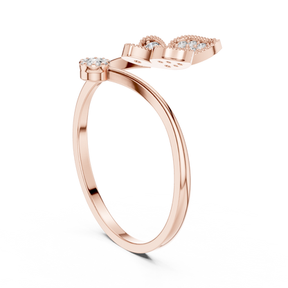 Rose gold ring with unique open design and diamond accents on black background