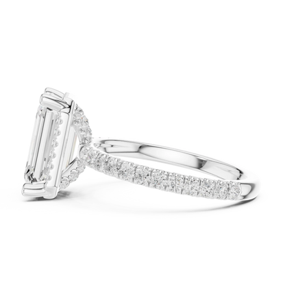 Side view of white gold emerald cut solitaire ring highlighting hidden halo and thin pav茅 band design
