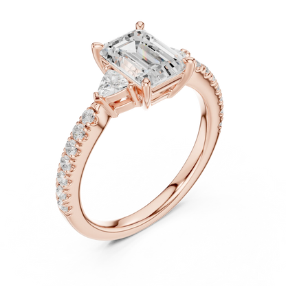 Front view of rose gold emerald three stone diamond pave ring, showcasing gemstone brilliance.