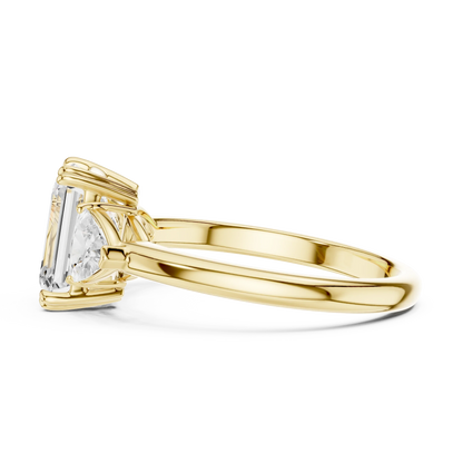 Side view of yellow gold emerald three-stone ring with trillion cut side stones and lab-grown diamond 鈥?Australia