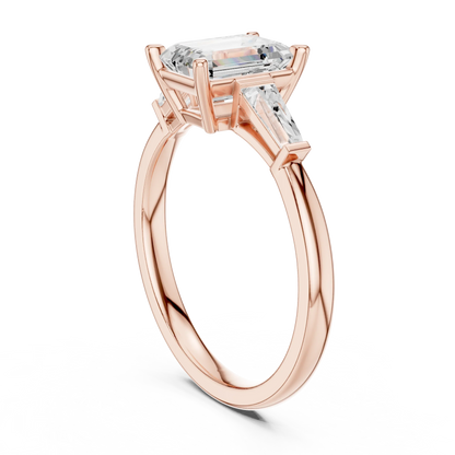 Rose gold emerald three-stone ring with tapered baguette side stones back view