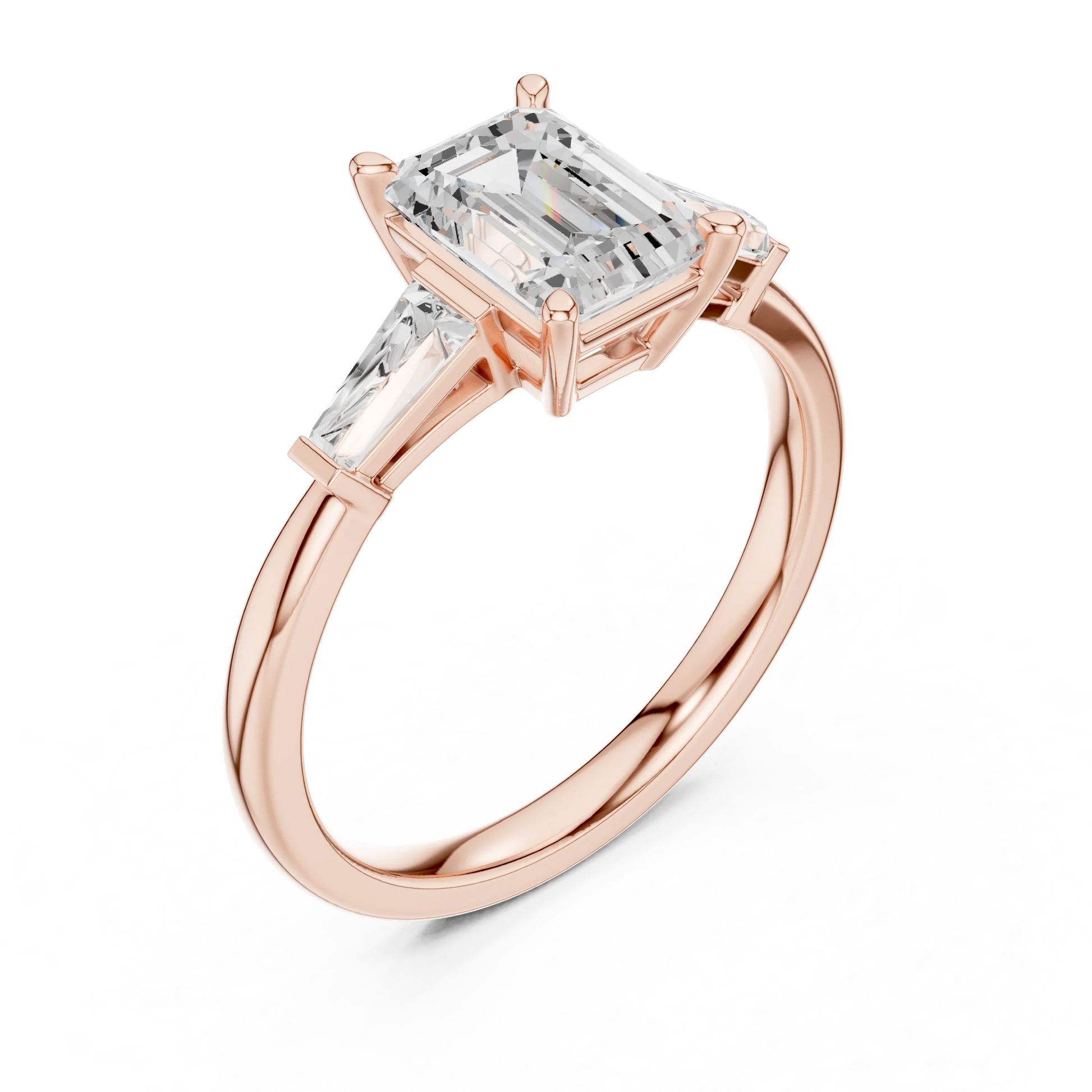 Rose gold emerald three-stone ring with tapered baguette side stones front view