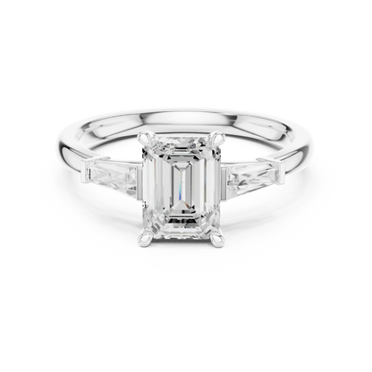 White gold emerald three-stone ring with tapered baguette side stones