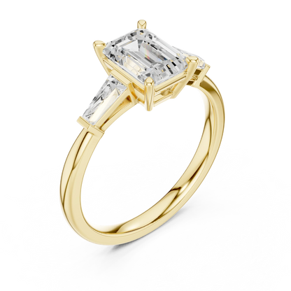 Yellow gold emerald three-stone ring with tapered baguette side stones front view