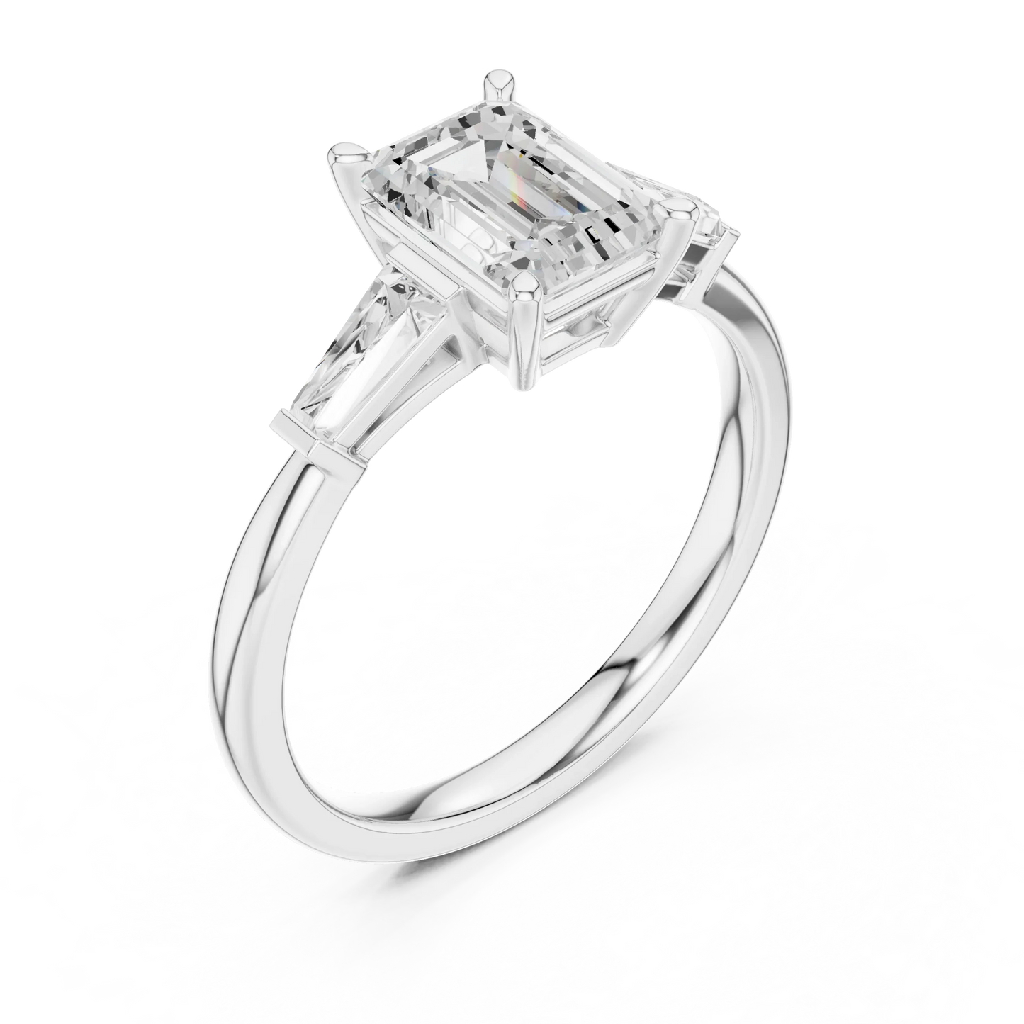 White gold emerald three-stone ring with tapered baguette side stones top side view
