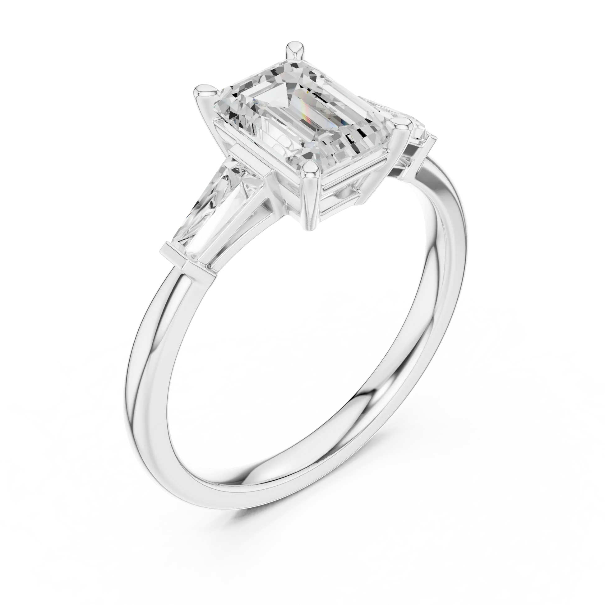 White gold emerald three-stone ring with tapered baguette side stones top side view