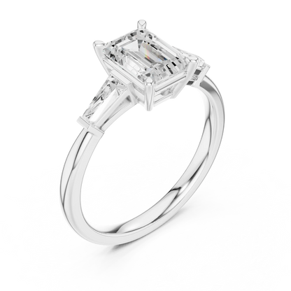 White gold emerald three-stone ring with tapered baguette side stones top side view