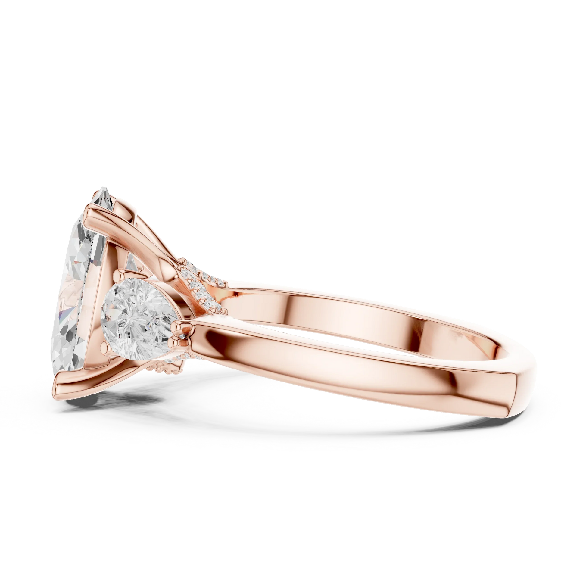 Side view of rose gold oval three stone ring highlighting pear side stones and diamond setting