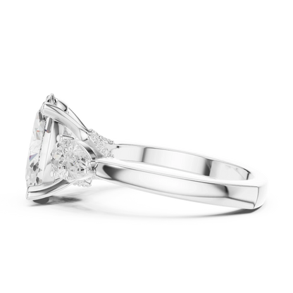 Side view of white gold oval three stone ring highlighting pear side stones and diamond setting
