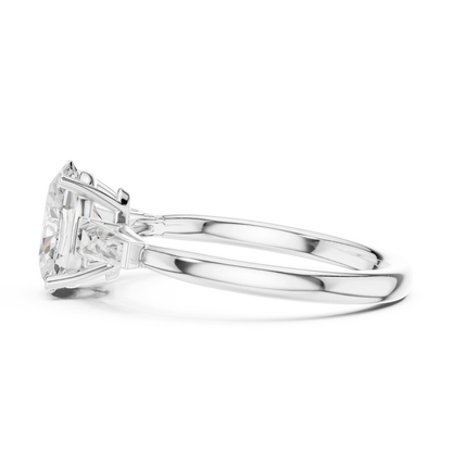 Side view of white gold oval three stone ring highlighting tapered baguette side stones and diamond setting