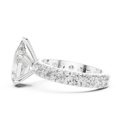 Side view of white gold pear cut solitaire ring highlighting pave band and prong setting