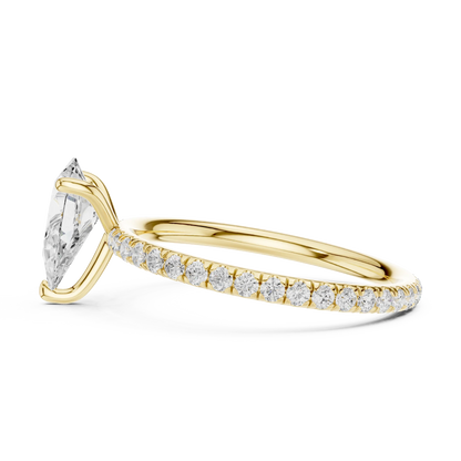 Side view of yellow gold pear cut solitaire ring with thin pavé diamond band and prong setting