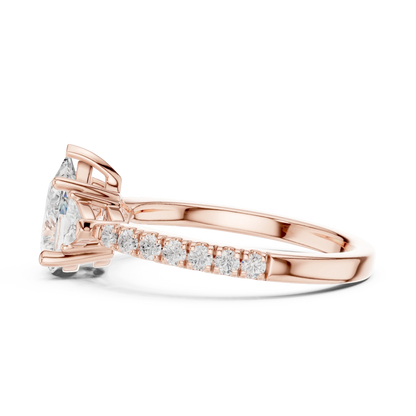 Side view of rose gold pear three stone diamond ring with half moon side stones and pave band, highlighting overall design profile.