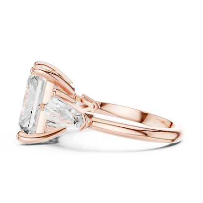 Side view of rose gold radiant three stone ring highlighting trillion side stones and diamond setting
